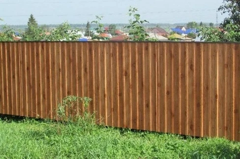 Сплошной забор из профлиста под дерево на сваях